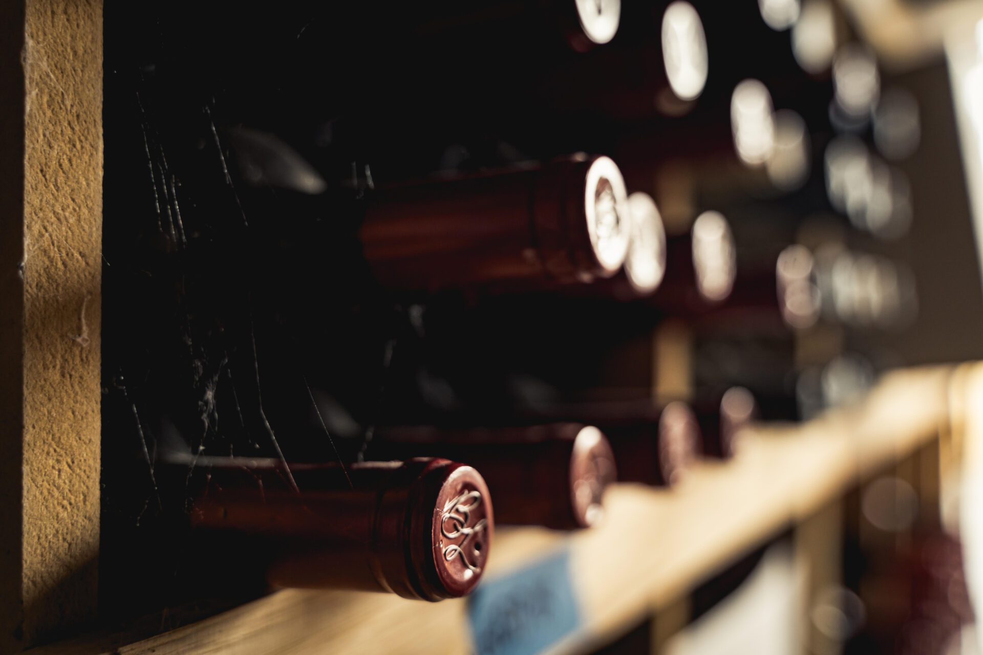 An array of Bella Luna Estate wine bottles elegantly arranged on a wooden shelf, showcasing a collection of fine wines with distinct labels and shapes.